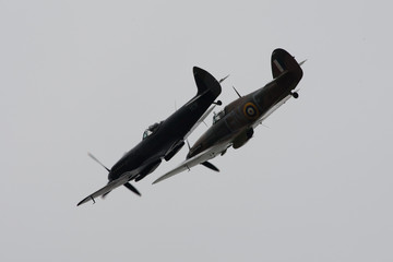 Fototapeta na wymiar Spitfire and Hurricane world war 2 fighters in close turning formation with light grey background