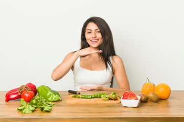 Young curvy woman preparing a healthy meal holding something with both hands, product presentation.