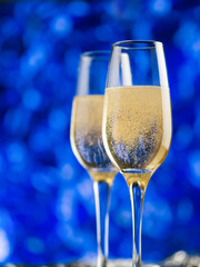 Two glasses of champagne on a blue background. Merry Christmas and happy new year