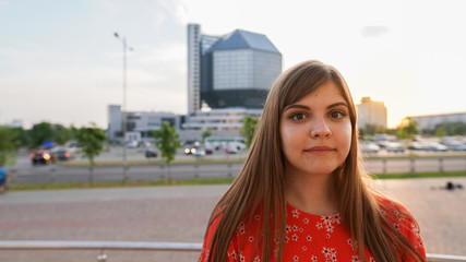 Fototapeta na wymiar Close Up portrait of a Happy young beautiful woman. Pretty girl dreaming. Looking in camera. City ​​park background.Concept of dreams and smart thoughts