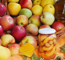 Compote of peaches in a glass jar and  background yellow, red apple