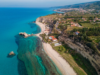 Aerial view of the Calabrian coast, villas and resorts on the cliff. Transparent sea and wild...