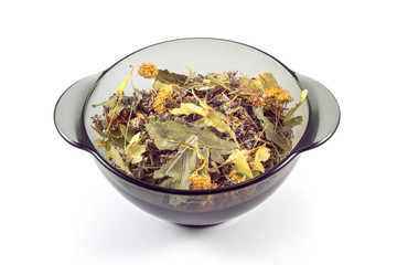  Mix of dried medicinal herbs in a black transparent plate on a white background