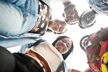 Fototapeta na wymiar Group of five african college students spending time together on campus at university yard. Black afro friends studying. Education theme. View from down.