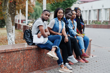 Group of five african college students spending time together on campus at university yard. Black afro friends studying. Education theme. - obrazy, fototapety, plakaty