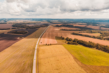 Panorama aerial view shot on road in the fields.Top View of Rural Road. Farm fields from above