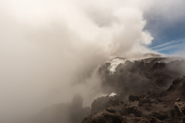 People walking on Mount Etna, active volcano on the east coast of Sicily, Italy. Panorama of Mount Etna the highest volcano in Europe.