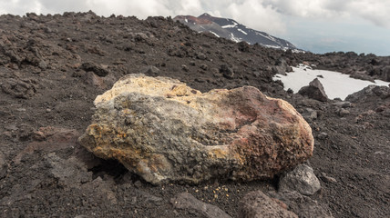 People walking on Mount Etna, active volcano on the east coast of Sicily, Italy. Panorama of Mount Etna the highest volcano in Europe.