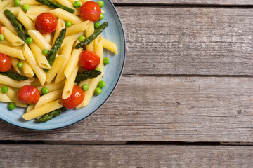 Penne pasta salad with asparagus , tomatoes and peas
