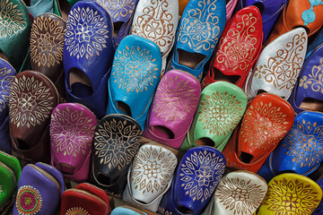 Obraz premium Colourful moroccan babouches displayed on a wall shelf.