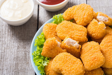 Chicken nuggets in plate on rustic background