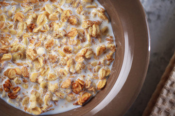 Baked granola with milk in a plate. Muesli with yogurt in a bowl. Healthy breakfast. Close-up.