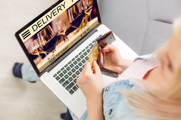 Fototapeta premium Woman laptop with app delivery food wine screen