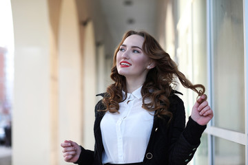 Business lady in strict clothes on the background of buildings