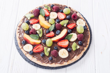 Fruit pizza with nut nougat cream , fruit and berries