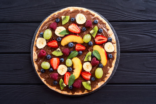 Fruit pizza with nut nougat cream , fruit and berries
