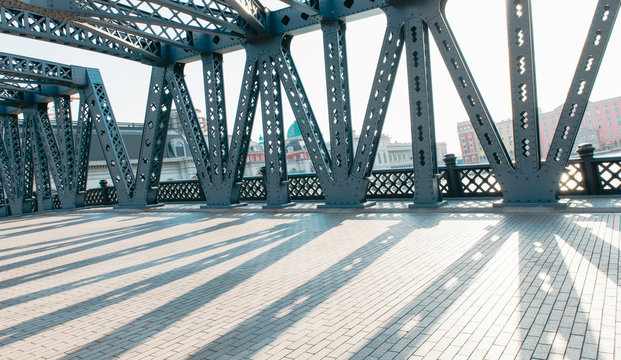 The road bridge with all steel beams in the sunlight has clear steel beam shadow on the road surface © 忆江
