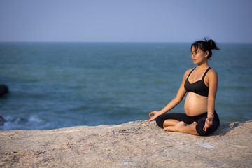 Fototapeta na wymiar Asian pregnant woman yoga on the beach sunset summer time
