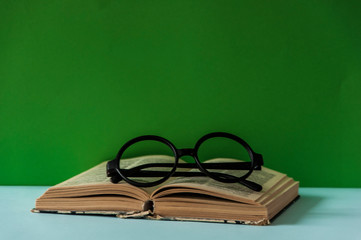 Book and glasses on colorful background