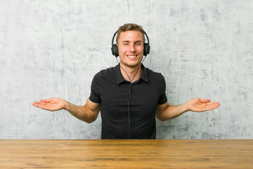 Young caucasian man listening to music with headphones showing a welcome expression.