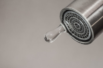 Leaking tap with a dripping drop of water. Call plumbing to eliminate leaks.