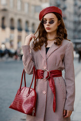 Outdoor fashion portrait of young elegant luxury lady wearing houndstooth print autumn coat, trendy...