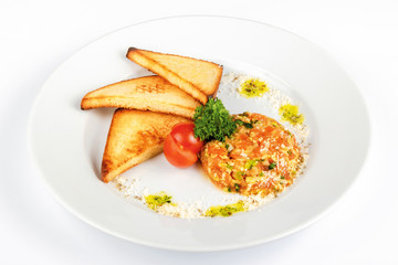 Beef steak tartare with croutons. raw beef with onions on the white plate decorated with cherry tomato. top view
