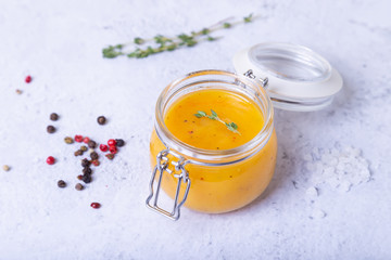 Orange sauce for duck (poultry) in a glass jar. Close-up, selective focus.