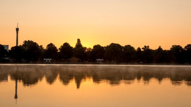 Beautiful sunrise time lapse shot with mist floating across the huge artificial lake Maschsee in Hannover, Germany.
