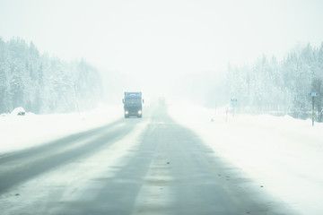 snow and fog on the winter road landscape / view of the seasonal weather a dangerous road, a winter...