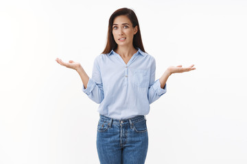 Uncomfortable awkward adult female coworker shrugging, clench teeth sorry expression, apologizing unaware not know information, spread hands sideways clueless, no idea gesture, white background - obrazy, fototapety, plakaty