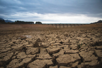 Big cracks in an arid an dry ground of a desert caused by severe drought.