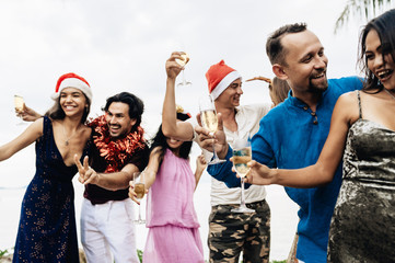 Friends celebrating Christmas or New Year eve at the beach.