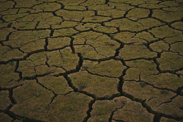 Big cracks in an arid an dry ground of a desert caused by severe drought.