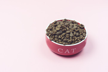 Dry Cat Food in Red Bowl with the Inscription on Pink Background Top View Horizontal Copy Space