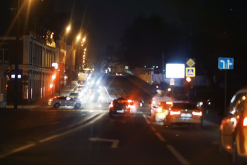 view of car in  traffic jam / rear view of the landscape from window in car, road with cars, lights and the legs of the cars  night view