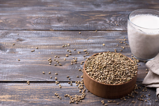 Hemp seeds in a wooden bowl and hemp milk on a wooden background with free space. superfood, healthy natural vegan food