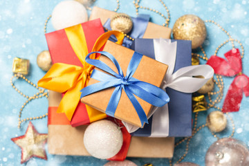 A stack of gifts and Christmas decorations on a blue background. Gift concept for a loved one, holiday, Christmas. Flat lay, top view