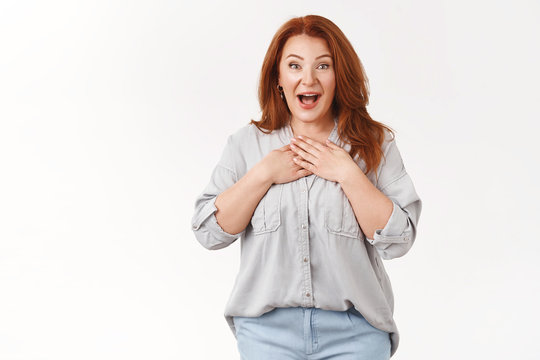 Such Pleasant Surprise Darling. Amused Excited Middle-aged Lucky Optimistic Redhead Woman Smiling Broadly Hands Chest Appreciation Gladly Receive Gift Standing Impressed Thankful, White Background