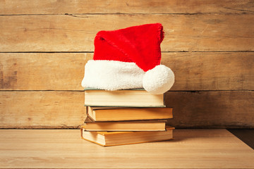 Stack of books, Santa's hat on a wooden background. Holiday concept, christmas, christmas eve