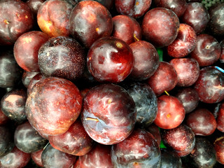 Texture of red plum in shop close up top view. Box with plums in store