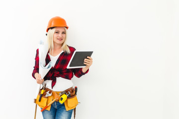 Fototapeta premium working woman in helmet with tablet isolated on white