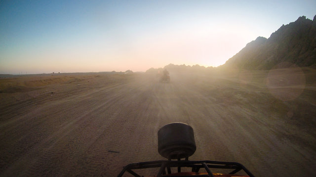 Girls drive quad biike.Desert in Egypt. Sharm el Sheikh. Sand and Sand Borkhan. Rock and sunset. Quad Cycle Travel. Excursion with people.Extreme sports & fun outdoors activities