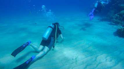 Fototapeta na wymiar Diving with air balloon in the red sea. Instructor. Girl and coral reefs. Traveling lifestyle. Water sports. Beach holidays.