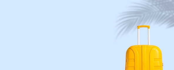 Yellow suitcase under the shadow of palm leaves on a blue background. Travel and vacation concept in triples. Banner. Flat lay, top view