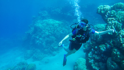 Fototapeta na wymiar Diving with air balloon in the red sea. Instructor. Girl and coral reefs. Traveling lifestyle. Water sports. Beach holidays.