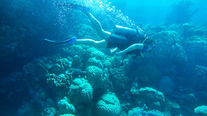 Obraz na płótnie Canvas Diving with air balloon in the red sea. Instructor. Girl and coral reefs. Traveling lifestyle. Water sports. Beach holidays.