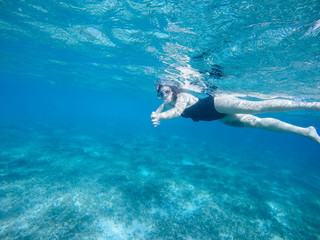 Fototapeta na wymiar Diving in the red sea. Sexy girl in bikini and mask. Snorkeling. Traveling lifestyle. Water sports. Beach holidays.