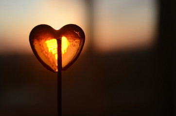 transparent sugar heart on sunset background