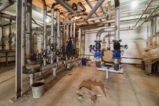 pumping station under construction. pipes of central heating system and water pipes with thermal insulation. Electric motor water pump under repair process at power plant. Industrial zone. 